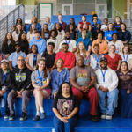 Summer Academy teachers and staff pose for a group photo on the blue stairs at the start of the program.