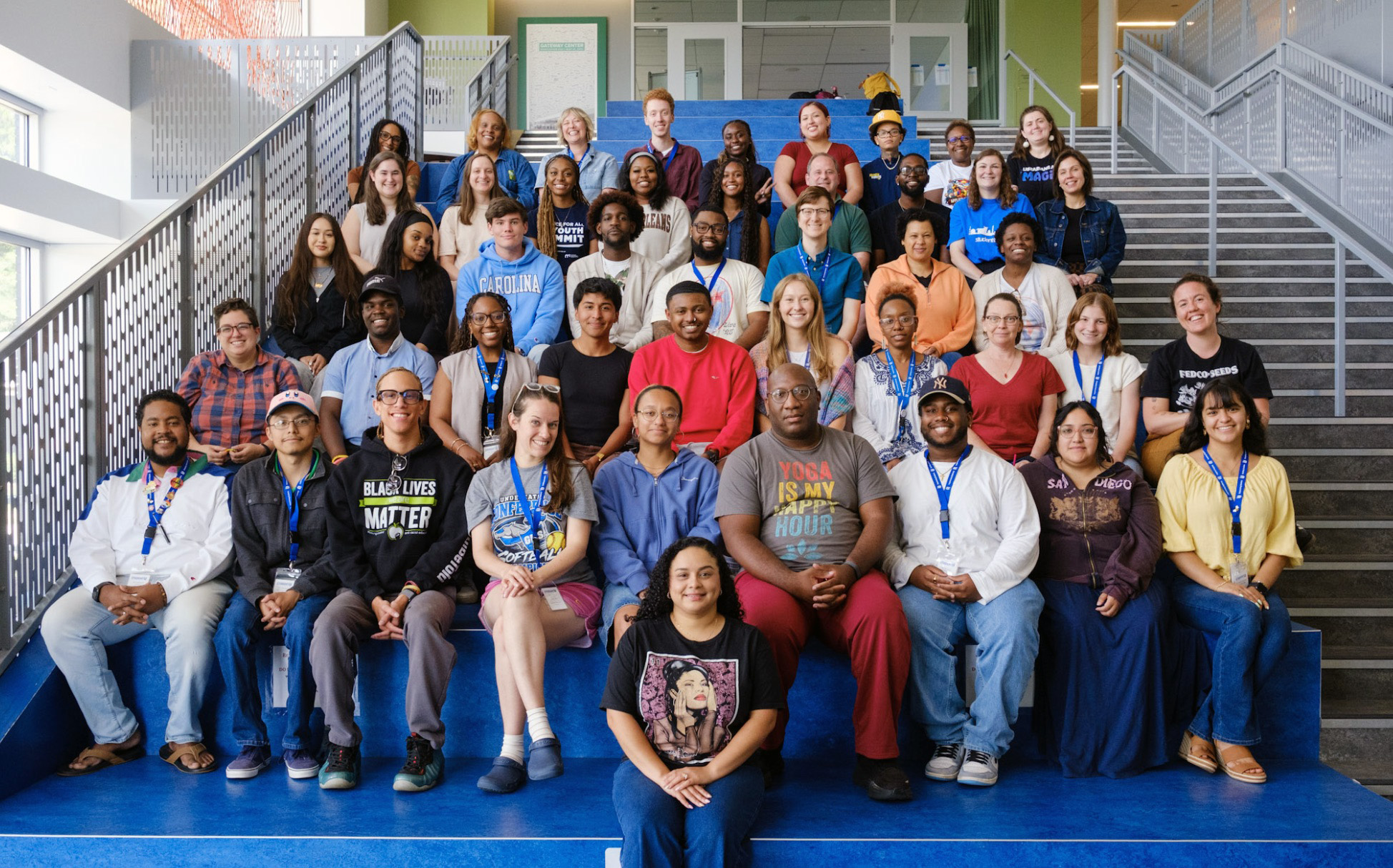 Summer Academy teachers and staff pose for a group photo on the blue stairs at the start of the program.
